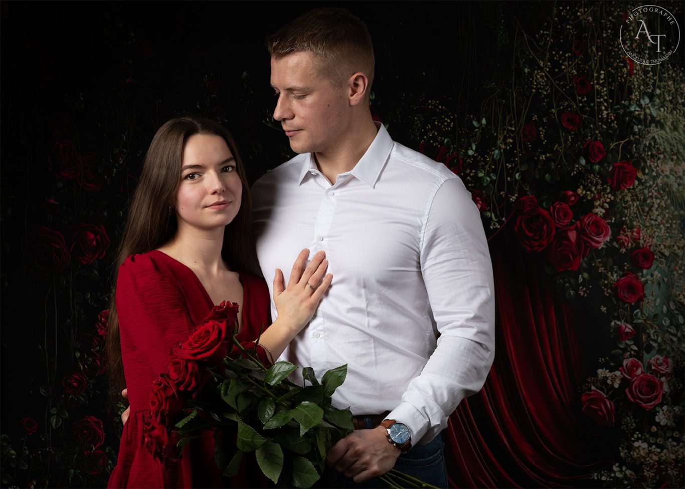 Anaïs et Pierre Un couple se tient près l'un de l'autre, entouré de roses et d'un fond sombre.